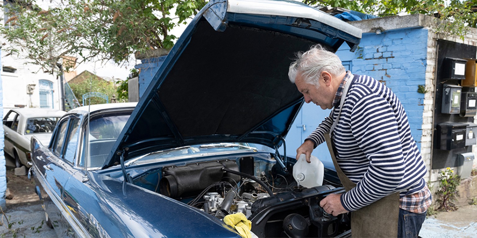 photo of man working on his car